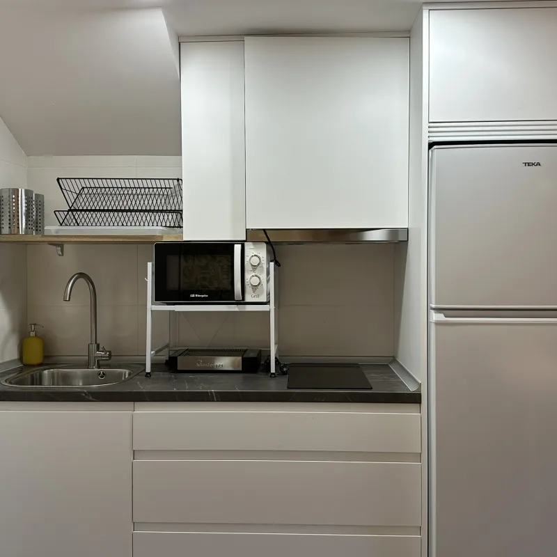 Cocina compartida del albergue con nevera, microondas y menaje