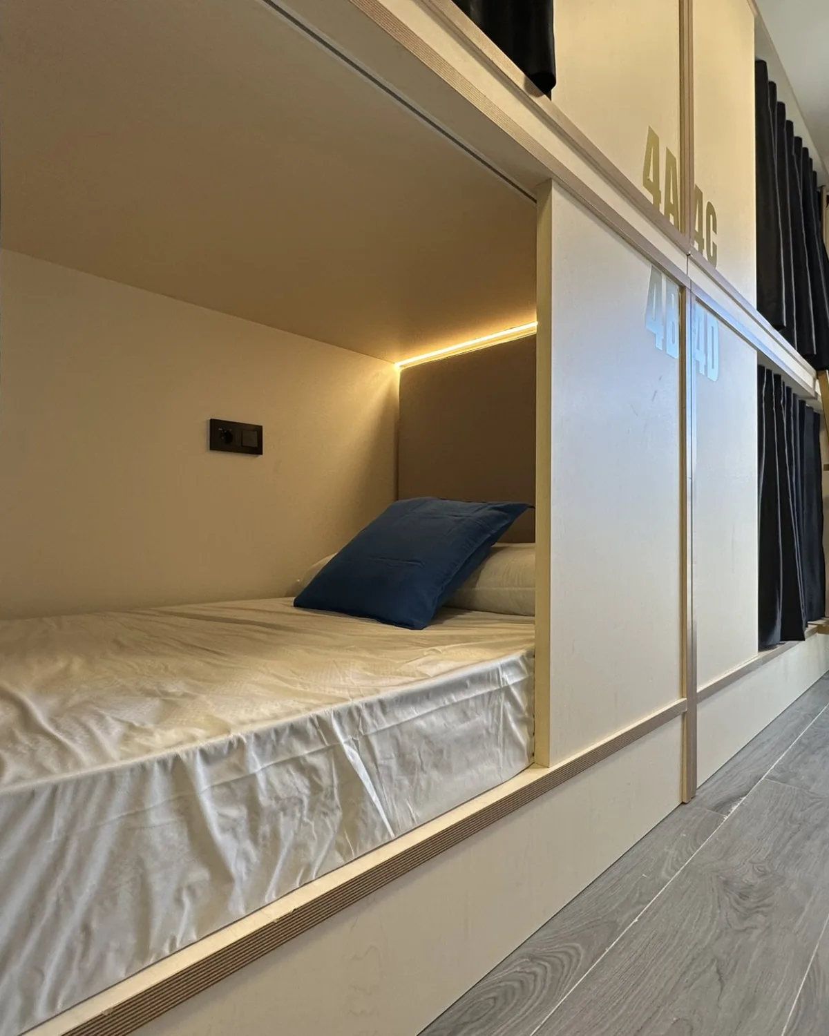 Literas con cortina y luz de lectura en una habitación del Albergue Manuela Inn