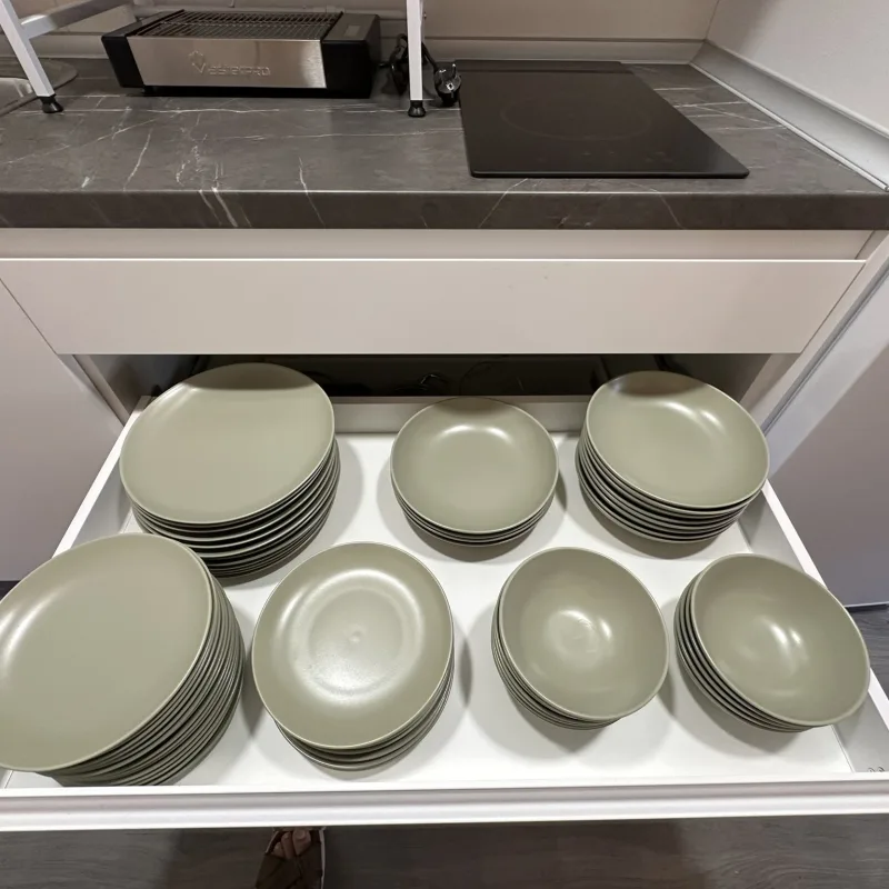 Cajón con platos de la cocina del albergue
