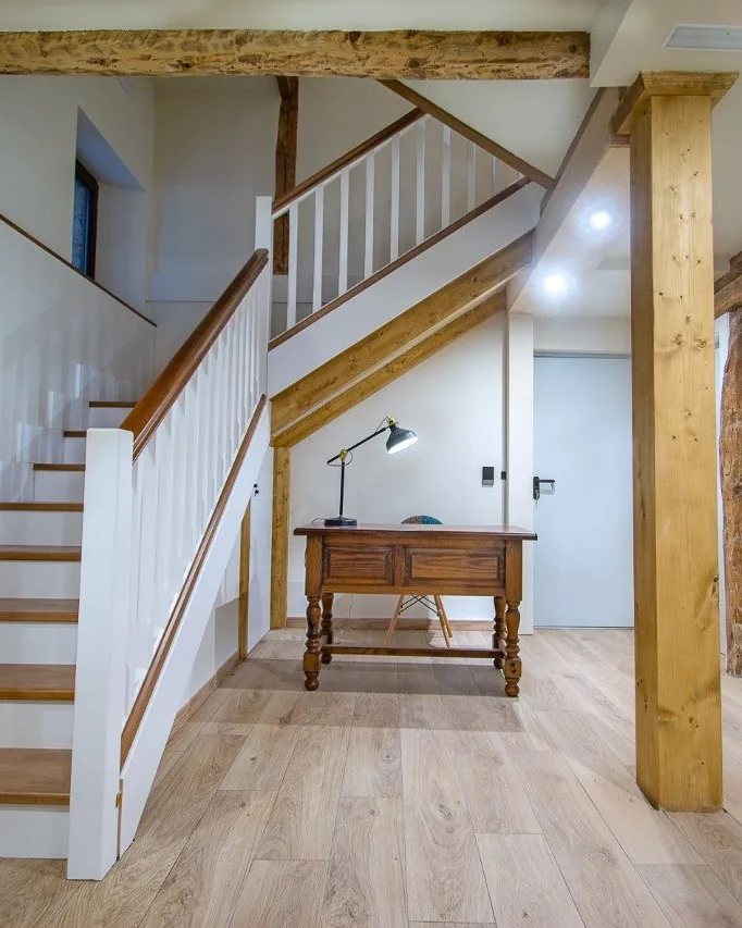 Escalera de madera y vigas vistas en el portal de los apartamentos