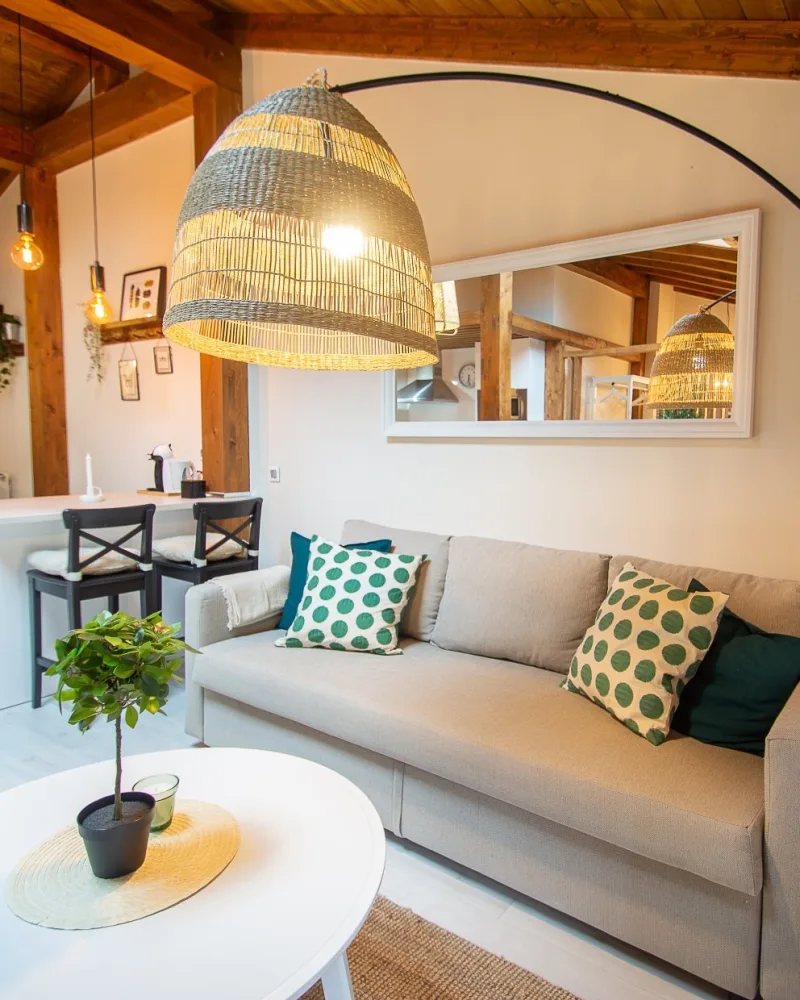Salón abuhardillado del ático KARA con vigas de madera y sofá