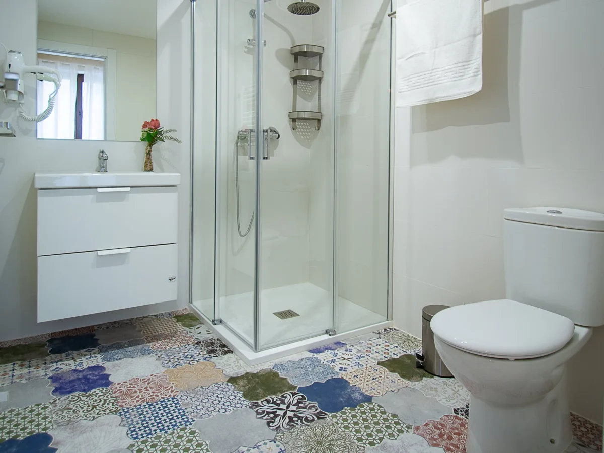 Baño con ducha y suelo de baldosa hidráulica