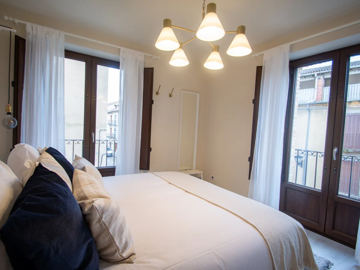 Dormitorio con cama de matrimonio y balcones
