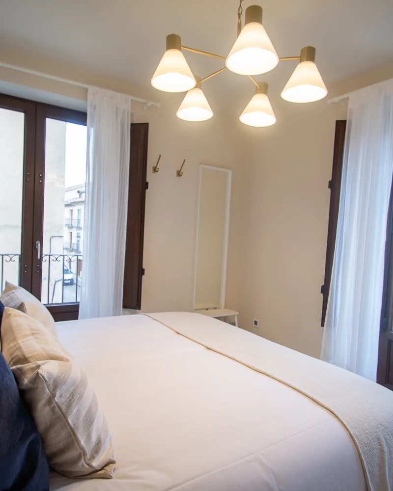 Dormitorio del apartamento STENA con cama de matrimonio y balcones