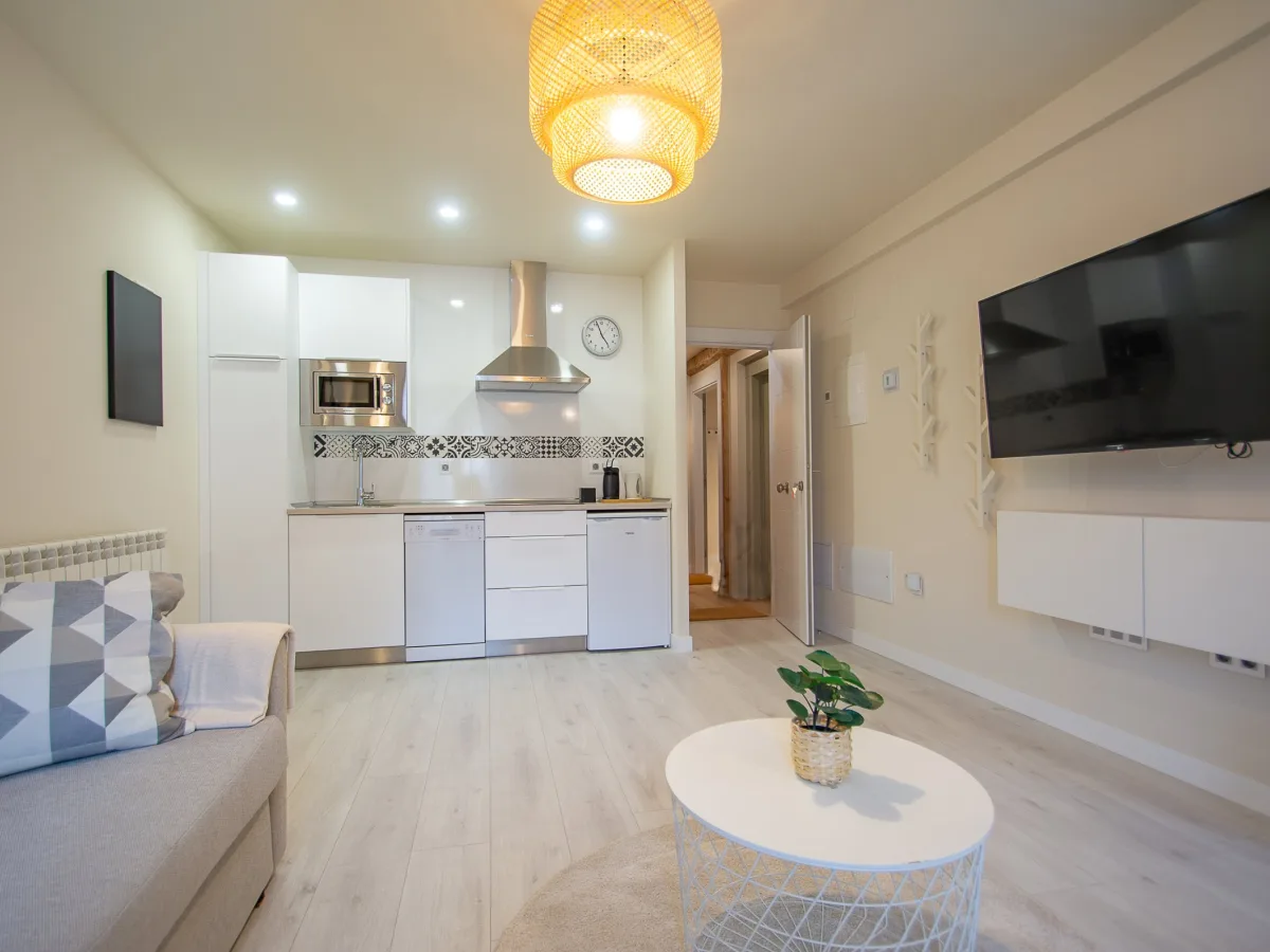 Salón con cocina abierta y televisión
