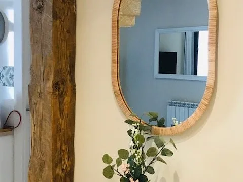 Espejo ovalado junto a una viga de madera