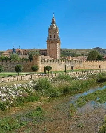 Murallas medievales y torre de la catedral junto al río Ucero