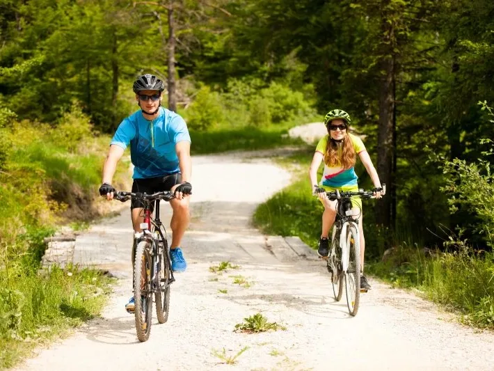 Pareja de ciclistas por un camino forestal